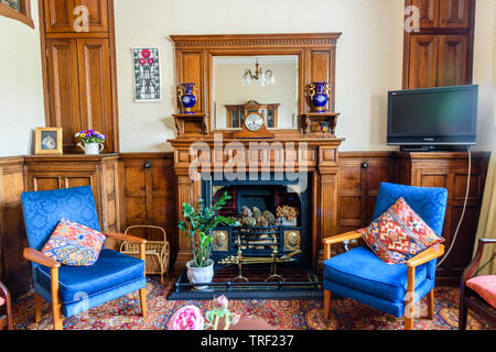 Mirror above the fireplace in a living room, decorated in Edwardian Style. Stock Photo