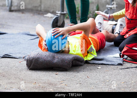 First aid after work accident, injured worker on a construction site Stock Photo