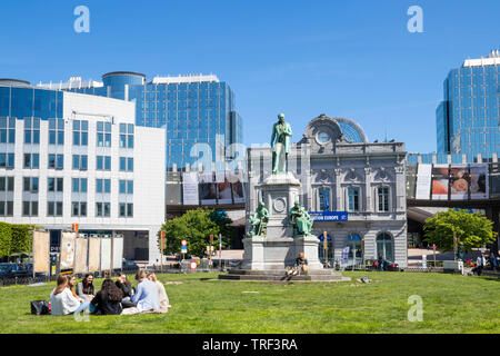 People on the grass in Place du Luxembourg PLUX Luxembourg Square Place du Luxembourg Ixelles statue of John Cockerill Brussels Belgium Eu Europe Stock Photo
