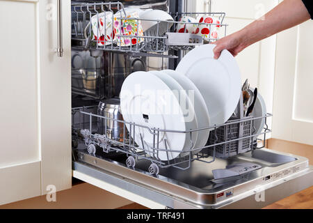 Woman unloading clean dishwasher