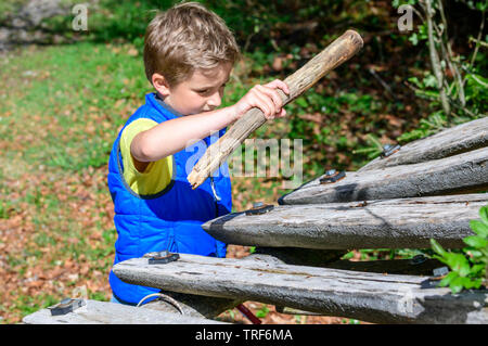 Discovering nature with the kids in springtime near Ofterschwang in Upper Allgäu, playing a wooden xylophone Stock Photo