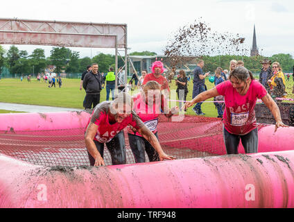 Warrington, UK. 2nd June 2019. Race for Life 2019, Warrington, in aid of Cancer Research. Runners get soaked with muddy water at the mud pit Stock Photo