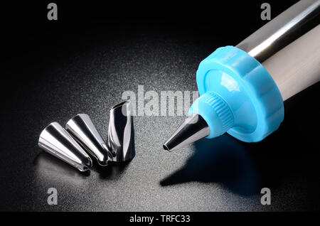 Icing pen on black grained surface of the table Stock Photo