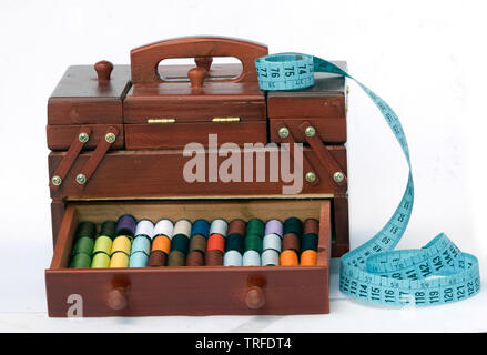 Wooden drawers with spools of colorful threads and measuring tape Stock Photo