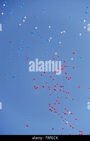 Multicolored balloons ore balls filled with helium flying in the blue sky Stock Photo