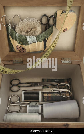 wood sewing box with scissors, bobbins and a sewing meter Stock Photo