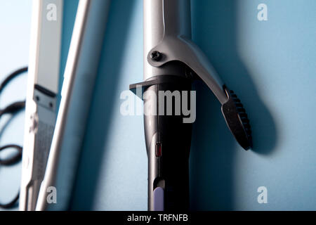 Close up of curling iron with flat iron in background Stock Photo