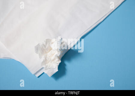 Close up of white tissues for nose blowing against blue background Stock Photo