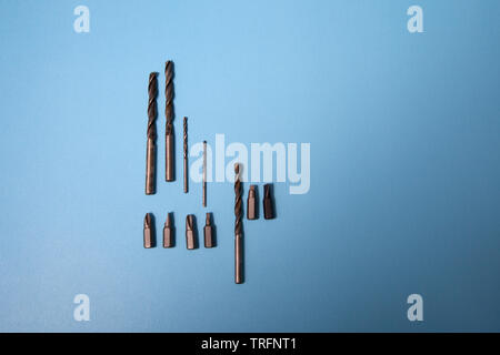 Drill heads and bits on a lay flat blue background Stock Photo
