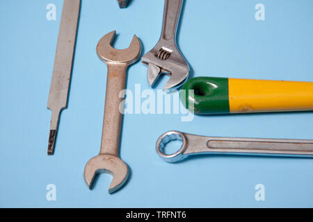 Close up looking at a metal work file, wrenches against a blue background ready for grip or shaving Stock Photo