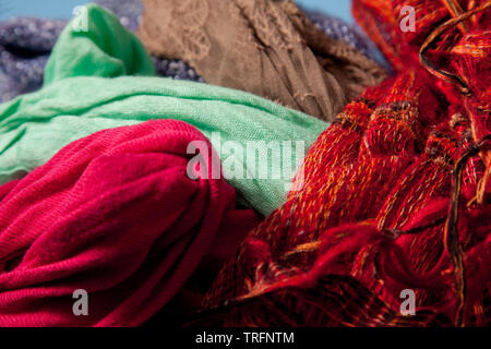 green, pink, red, blue and brown scarves all tangled together to make an interesting visual abstract Stock Photo