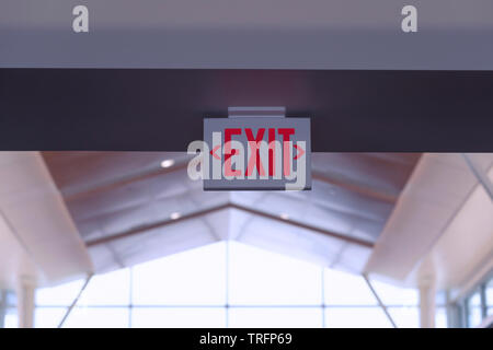 Exit Sign. Red Fire Escape Sign Hang on the Ceiling in the Airport. Stock Photo