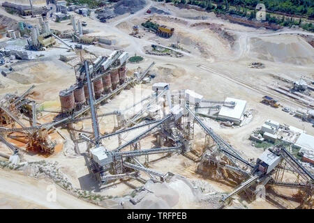 Large Quarry during work hours with Stone sorting conveyor belts - Aerial tour.