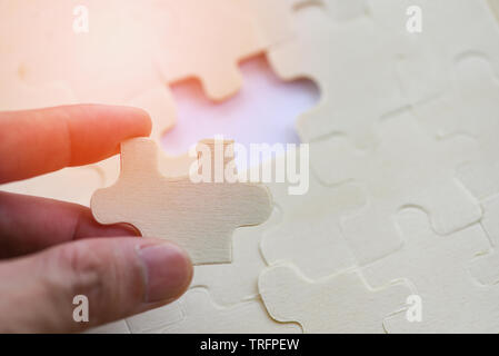 hand trying to connect jigsaw puzzle on background jigsaw piece connecting business solutions success and strategy concept Stock Photo