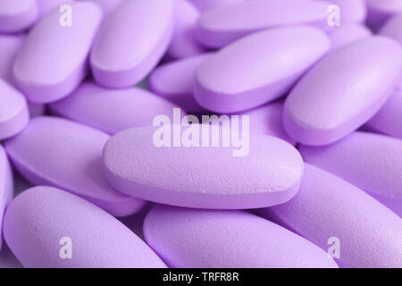 Macro shot of heap of pastel purple oval shaped supplement pills Stock Photo