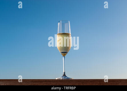 One glass of champagne isolated on blue sky background. Stock Photo