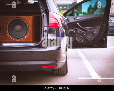 Car audio, car speakers, black subwoofer and sound amplifier on a blue
