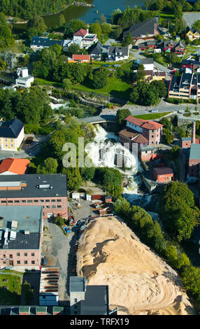 Aerial view over Mossefossen waterfall (center) at the outlet of the lake Vansjø. This area is in the northern part of the town Moss in Østfold, Norway. Down to the left is the paper mill Peterson Linerboard, which went bankrupt in 2011. The building to the right of the waterfall is called Druidegården, and it is a part of the Møllebyen area. The lake Vansjø and its surrounding lakes and rivers are a part of the water system called Morsavassdraget. September, 2006. Stock Photo