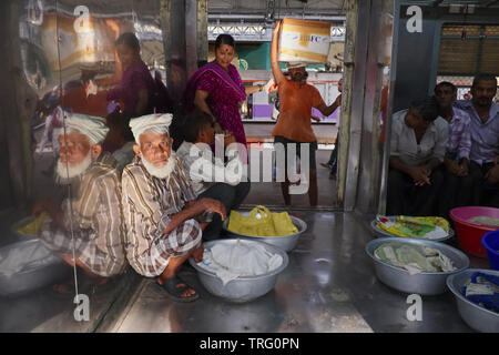 Porters in the freight compartment of a local train at Chhatrapati Shivaji Maharaj Terminus in Mumbai, India, the city's busiest railway station Stock Photo