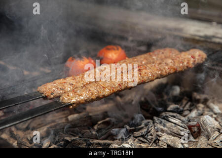 Kebab or kebap on metal skewer barbecue in the kebap restaurant. Traditional Turkish Adana Kebab Stock Photo