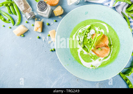 Healthy homemade green pea vegetable cream soup in a bowl on light blue slate, stone or concrete background. Copy space. Stock Photo