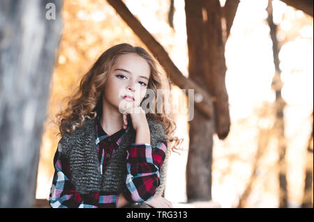 Teen girl 12-13 year old resting outdoors. Looking at camera. Childhood. Stock Photo