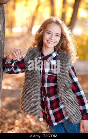 Beautiful teen girl 12-14 year old wearing casual stylish clothes posing  outdoors. Looking at camera. Autumn season. Stock Photo