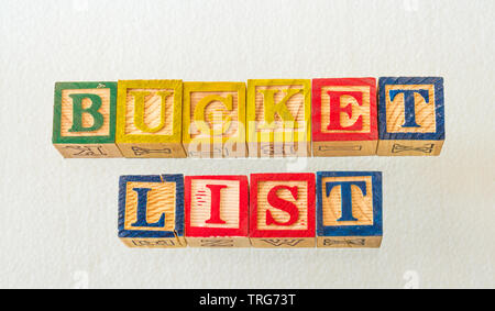 The term bucket list visually displayed using colorful wooden blocks on a clear surface image with copy space in landscape format Stock Photo