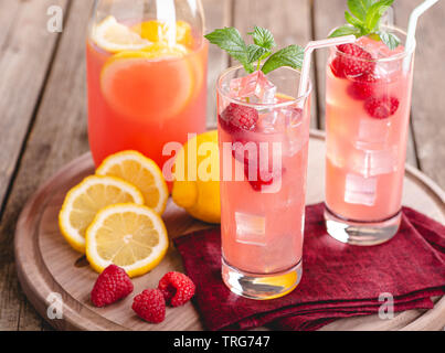 Two tall cocktail glasses with pink gin and tonic garnished with large  crystals of salt on an edge of a glass, large piece of ice, peppermint  Stock Photo - Alamy