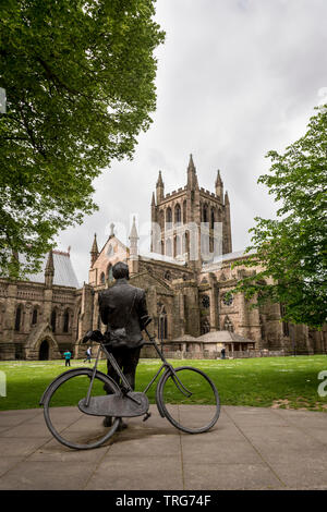 Looking up at Hereford Cathedral from the close with the statue of Sir Edward Elgar leaning on a bike in the foreground. Stock Photo