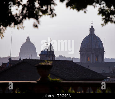 A view across Rome in the late evening. The domes of St Peter's Basilica, Vatican and Sant'Andrea della Valle can be seen silhouetted against the sky. Stock Photo