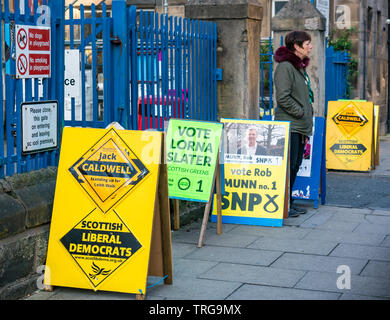 Man walking past Lorne Primary School polling place at Leith Walk Council By-Election, Edinburgh, Scotland, UK with party political boards Stock Photo