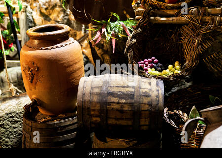 old clay pot next to wooden barrels to serve wine Stock Photo
