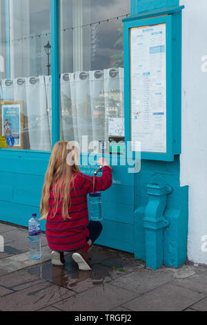 Child drawing tap water in Dartmouth Quay Stock Photo