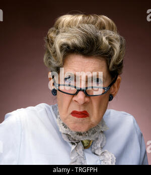 Grumpy old lady wearing glasses Stock Photo