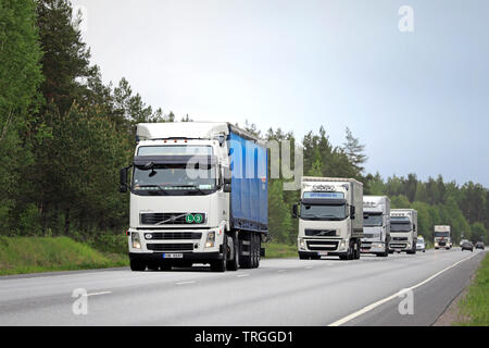 Raasepori, Finland. May 24, 2019. Fleet of white freight trucks, Volvo, Renault and DAF in highway traffic on a cloudy day of spring in Finland. Stock Photo