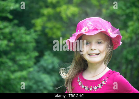 Outdoor fashion portrait of a cute little girl of 7-8 years old, wearing  pink top, skirt and headband Stock Photo by ©annanahabed 94957490