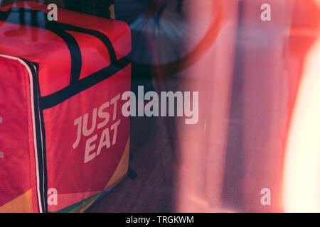 Valencia, Spain - June 1, 2019:: Just Eat  logo Colored logo on the backpack. Online food ordering, home delivery service. Food take away. Stock Photo