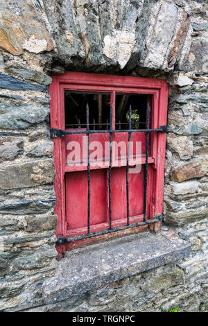 Old red wooden window on a stone wall of an abandoned building Stock Photo