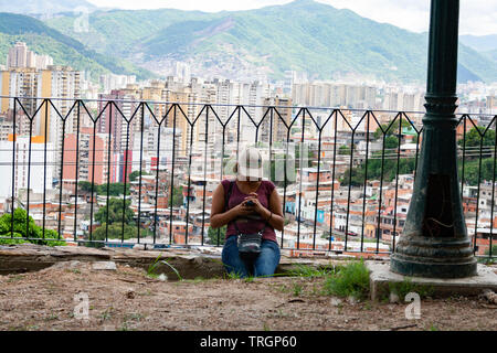Caracas,Venezuela. Woman texting in El Calvario Park, Ezequiel Zamora Park. Stock Photo