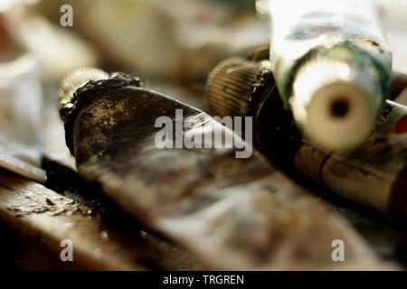 dirty tubes of black and green oil paint are in a mess on the palette Stock Photo