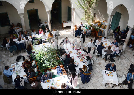 Tunisians having lunch at Fondouk El Attarine - a fine dining restaurant serving traditional Tunisian cuisine in the Medina of Tunis, Tunisia. Stock Photo