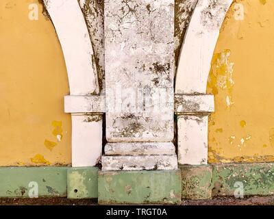 Details on old yellow white and green painted building exterior Stock Photo
