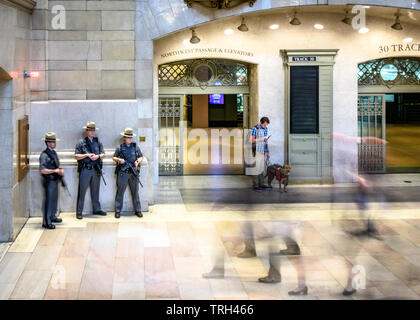 New York, USA,  21 May 2019. Heavily armed members of the New York State Police stand guard as travellers pass-by in New York City's Grand Central Sta Stock Photo