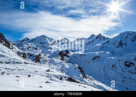 Snow covered mountains in the Talkeetna Mountain Range of Alaska. Snow is melting under a bright spring sun in April near Hatcher Pass Recreation Area Stock Photo