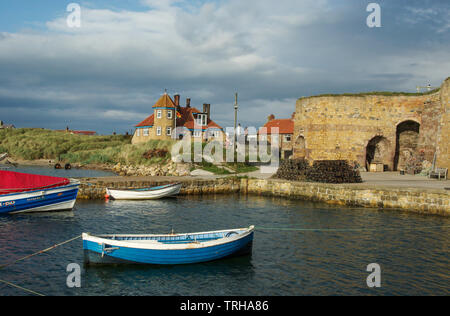 Fishing boats in Beadnell Harbour, Northumberland UK, with historic lime kilns in the background Stock Photo