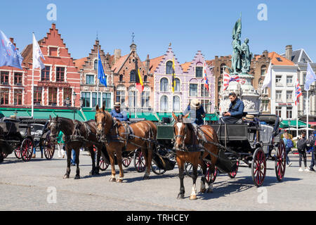 Horse drawn carriage rides for tourists in the Historic square the Bruges Markt in the centre of Bruges Belgium West Flanders EU Europe Stock Photo