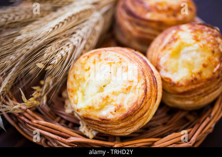 Cheese pastry buns  with ears of wheat, fluffy salty dessert Stock Photo