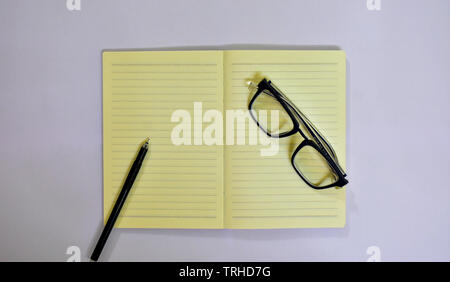 Picture of glasses and a pen on top of a diary. Stock Photo