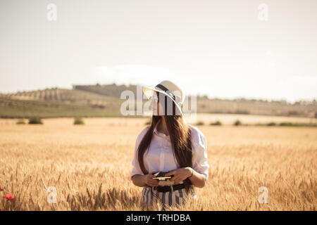 Young girl sitting on train rail track using her mobile phone and headphone Stock Photo